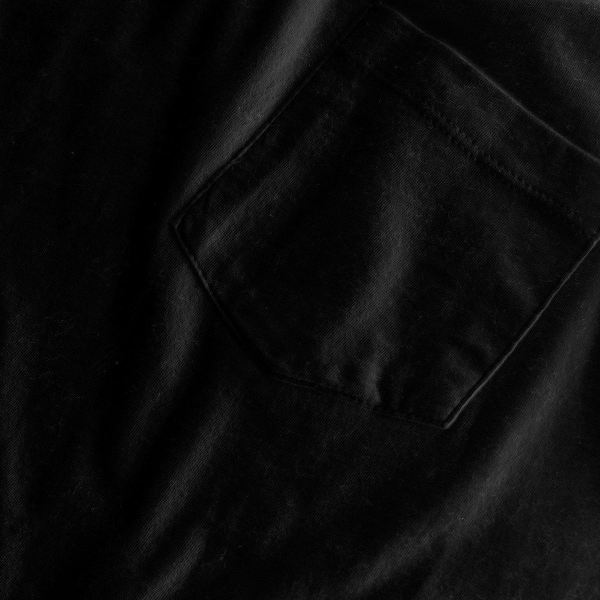 Black Pocket Crew Tee with visible cotton texture and stitched pocket.