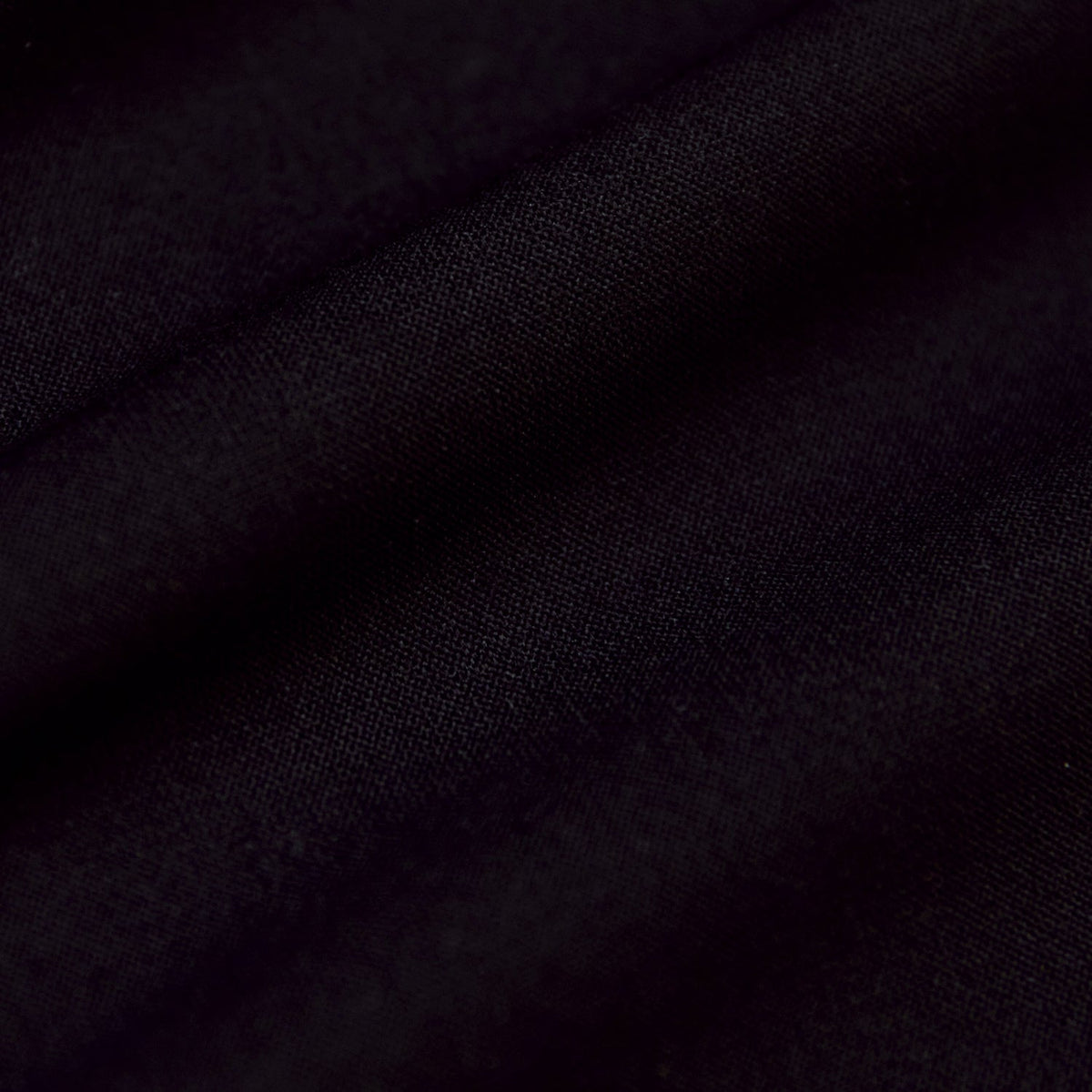 Black Active Polo 2.0 close-up showing fine weave and gentle folds.