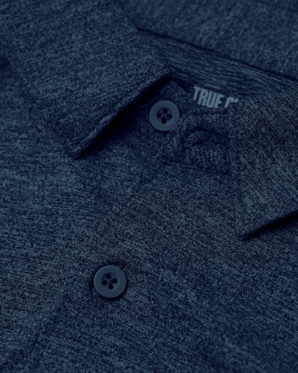 Close-up of a navy blue polo shirt with 'True Religion' branding.