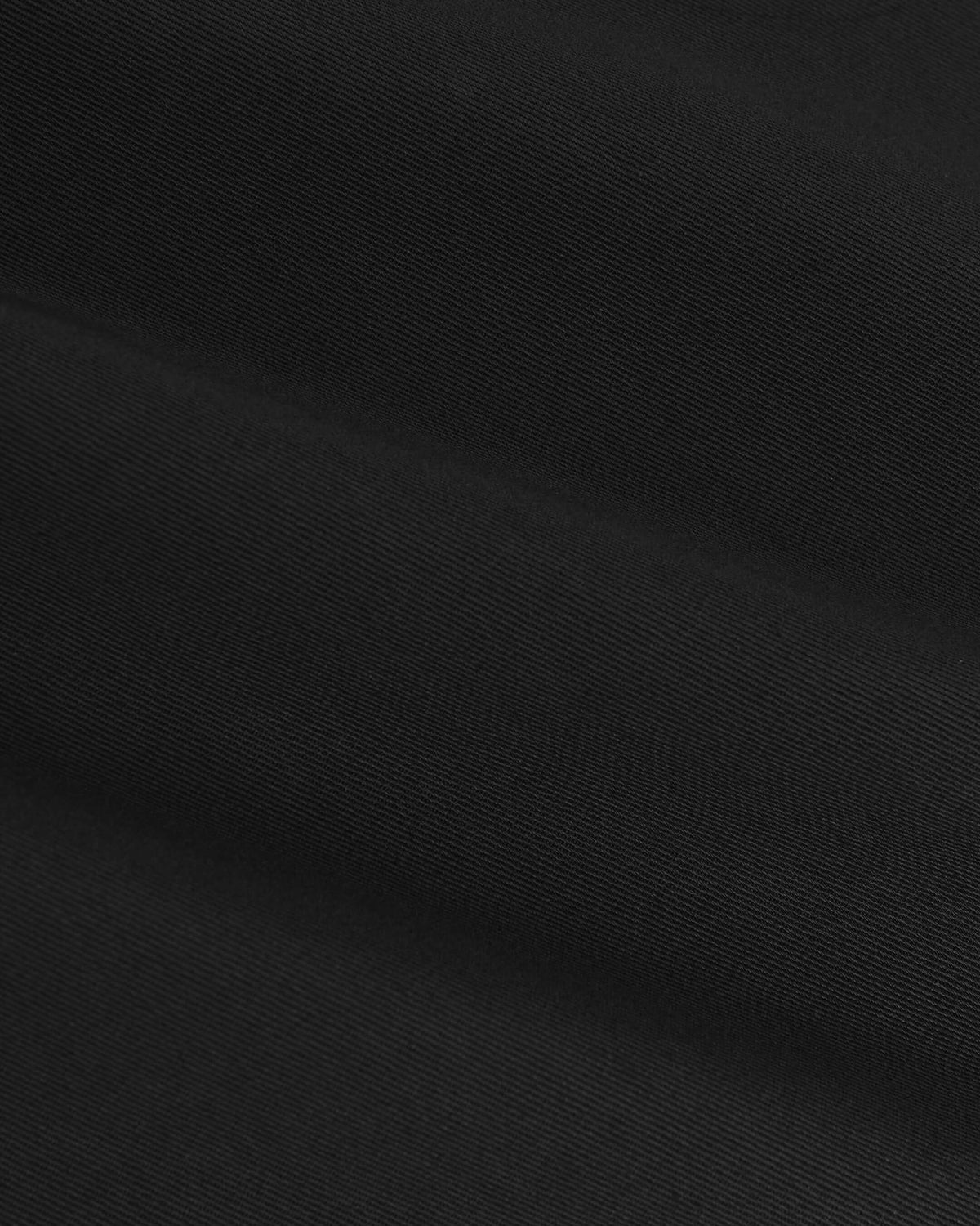 Black Coaches Jacket close-up, showcasing its diagonal twill weave and texture.