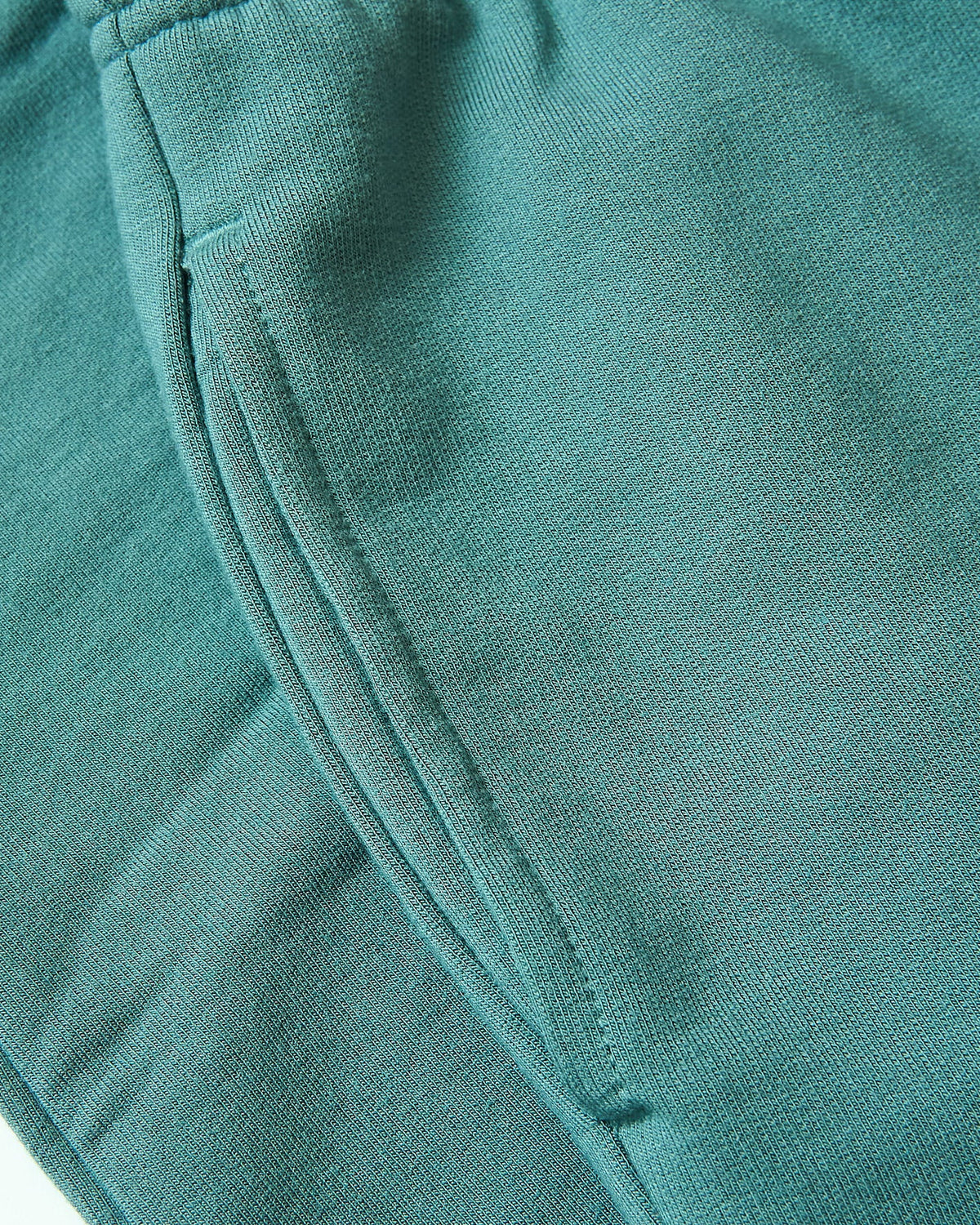 Girls Stormcloud Joggers detail: elastic waistband, teal-green knit, seam pocket.