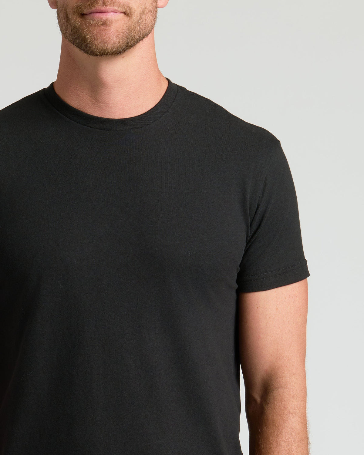 Black crew neck t-shirt with short sleeves on male model.