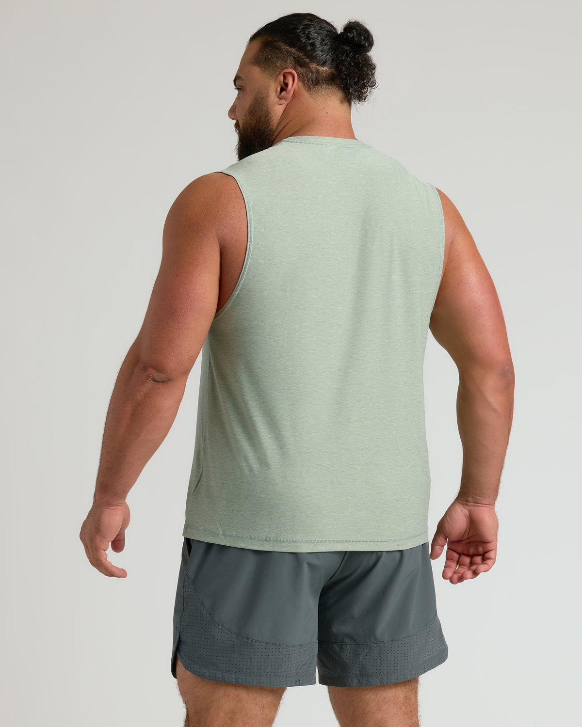 Man wearing Lichen Sleeveless Active Muscle Tee and dark gray shorts.