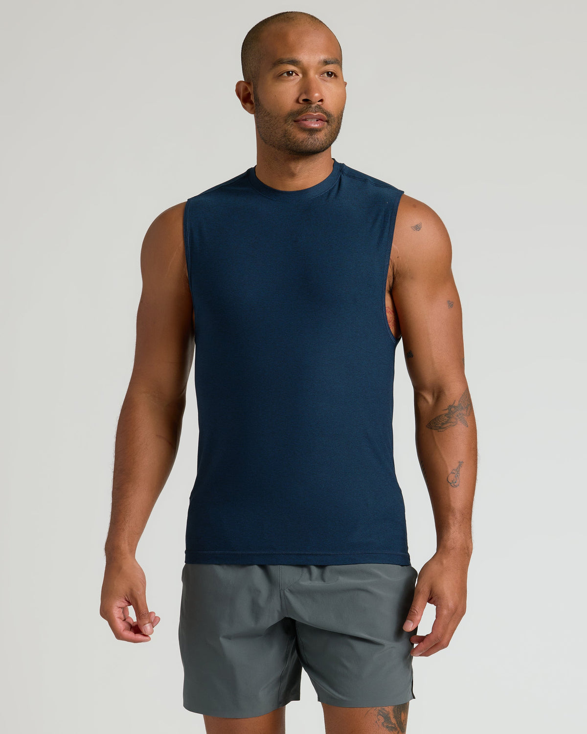 Man in Dark Heather Navy Sleeveless Active Muscle Tee, relaxed pose.