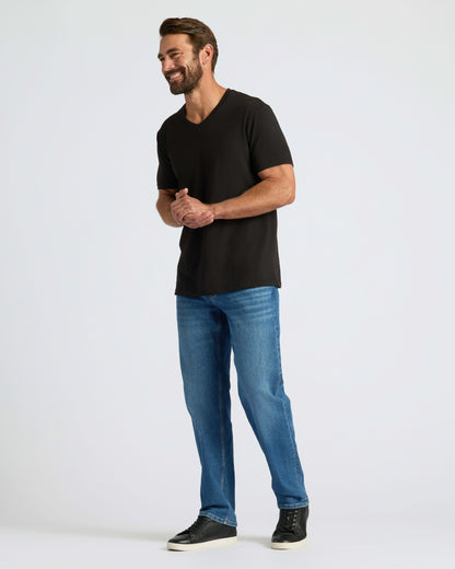 Man wearing Classic V-Neck with jeans and sneakers, smiling.